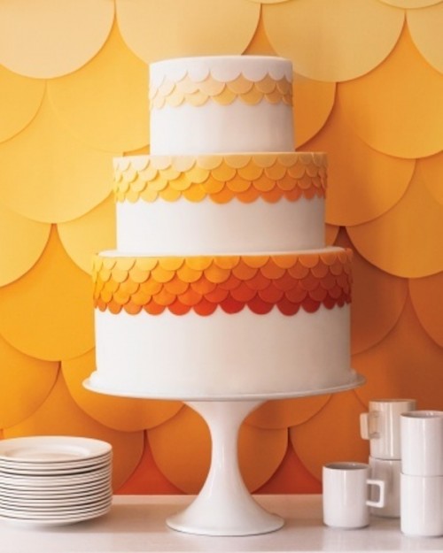 a white wedding cake decorated with orange scallops with an ombre touch is a great idea for a colorful wedding with touches of orange