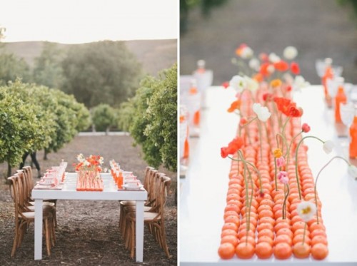 a bright wedding table runner of orange tangerins and white and orange blooms inserted is a super creative and fun idea for summer