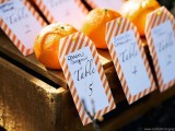 escort cards of tangerins, with striped tags are a great idea for a modern bright wedding with lots of orange