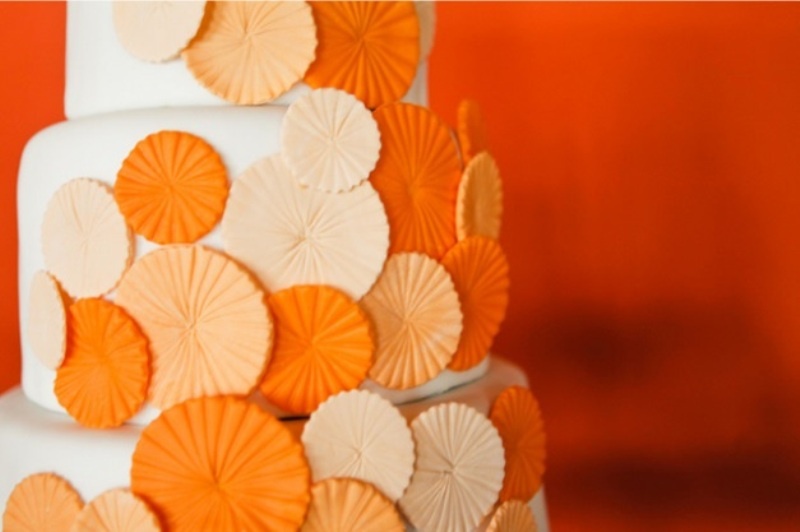 a neutral buttercream wedding cake decorated with neutral, blush and orange sugar circles is a great idea for a bright summer wedding