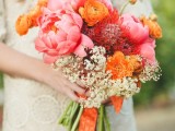 a super bright wedding bouquet of pink peonies, orange ranunculus, white blooms and orange ribbon is amazing for summer