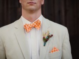 a neutral groom’s look with an orange printed bow tie and a matching handkerchief is a great idea for a bold summer wedding