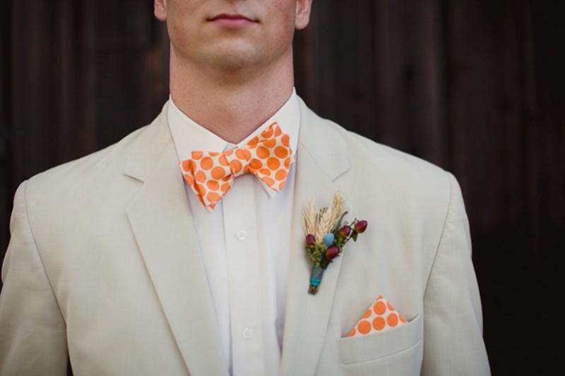 a neutral groom's look with an orange printed bow tie and a matching handkerchief is a great idea for a bold summer wedding