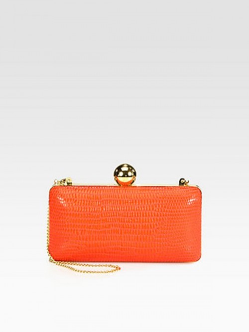 a bold orange leather clutch with pretty detailing is an eye-catchy accessory for a bride at a colorful wedding