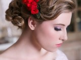 a red flower headpiece with leaves is a nice accessory to accent your winter bridal hairstyle