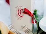 wedding stationery with red printing and a red ribbon bow for a winter or Christmas wedding
