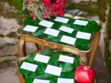 vintage wooden stools covered with leaves, cards, red blooms and a pomegranate for winter weddings