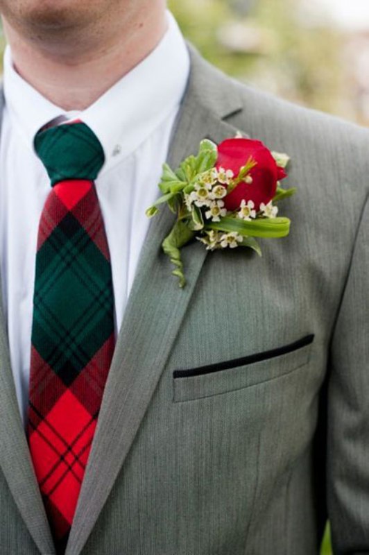 A plaid green and red tie plus a red rose boutonniere for accessorizing a winter or Christmas groom's look