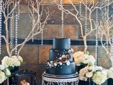 a midnight blue wedding cake with white and dark gold sugar blooms, pearls and beads is a refined and chic idea that will easily fit many weddings