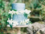 a textural blue wedding cake with white blooms and greenery is a stylish and chic idea for a spring, summer or even tropical wedding