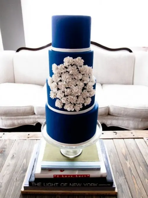 an electric blue wedding cake decorated with white meringues is a stylish and cool idea for a bold modern wedding, with a contrasting color scheme