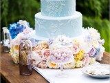 a serenity blue wedding cake with white patterns and pastel blooms at the bottom is a beautiful idea for a spring or summer wedding