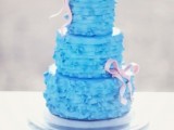 a bright blue ruffle wedding cake with pink ribbon bows is a cool idea for a modern wedding with plenty of color