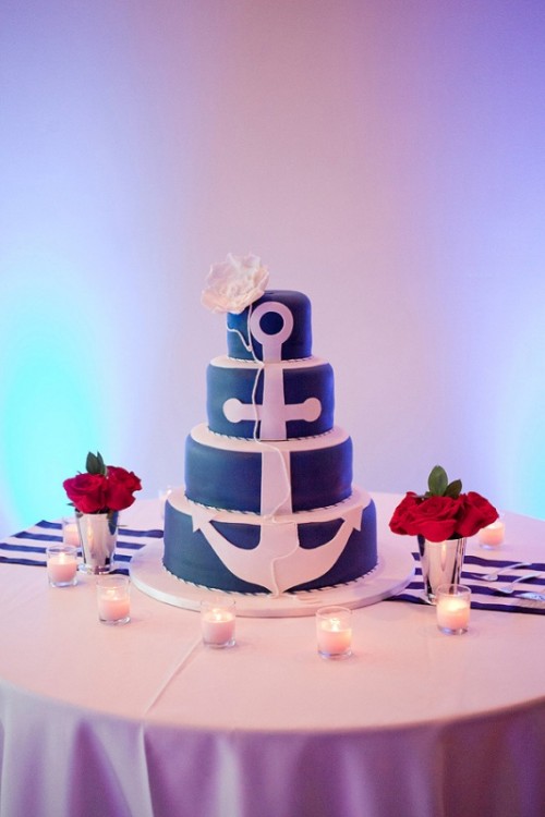 a navy wedding cake with a white anchor and a white sugar bloom on top is a lovely idea for a nautical wedding
