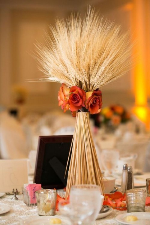 a simple rustic wedding centerpiece of wheat and orange roses for a refined rustic wedding