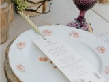 a wheat spike holding the menu in place on a place setting is a pretty and cool idea for a rustic summer or fall wedding