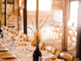 a wine bottle with wheat and lavender is a simple and very lovely idea of a centerpiece for a fall wedding