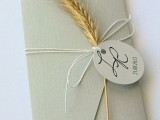 an envelope highlighted with a wheat spike and a tag is a lovely idea to pack your invitation for a rustic wedding