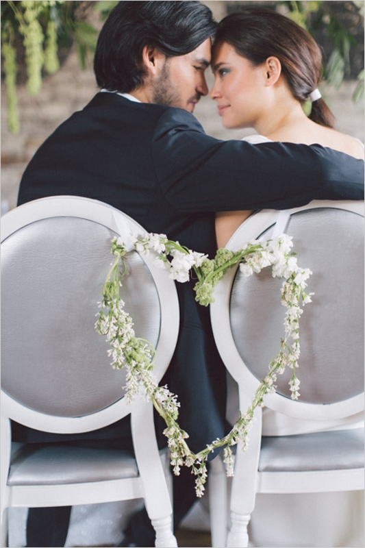 a green and white flower heart shaped wreath is a stunning idea for styling the couple's chairs
