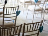 red and black fabric hearts accenting the wedding chairs instead of blooms and greenery are a very budget-friendly and eco-friendly idea