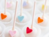 white cake pops accented with colorful sugar hearts look very cute and lovely and will add a touch of fun to your wedding dessert table