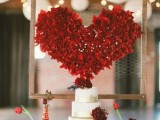 a gorgeous large red heart-shaped decoration over the wedding cake is a fantastic decor idea to rock