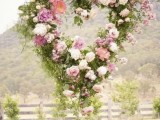 a greenery and pink and white heart-shaped wreath is a cool decor idea for a garden wedding