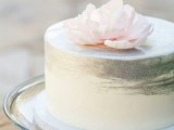 a subtle ombre white to silver one tier wedding cake topped with a pink bloom is a chic idea