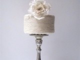 a white bead covered wedding cake topped with a large white fresh bloom is ideal for an elegant and chic wedding