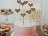 an ombre pink wedding cake with multiple glitter heart toppers is a bright and very glam idea