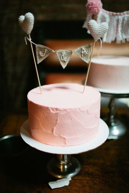 a pink textural one tier wedding cake with a burlap topper and hearts is a simple rustic idea