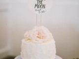 a textural white buttercream wedding cake topped with blush peonies on top and a romantic topper is a cute idea