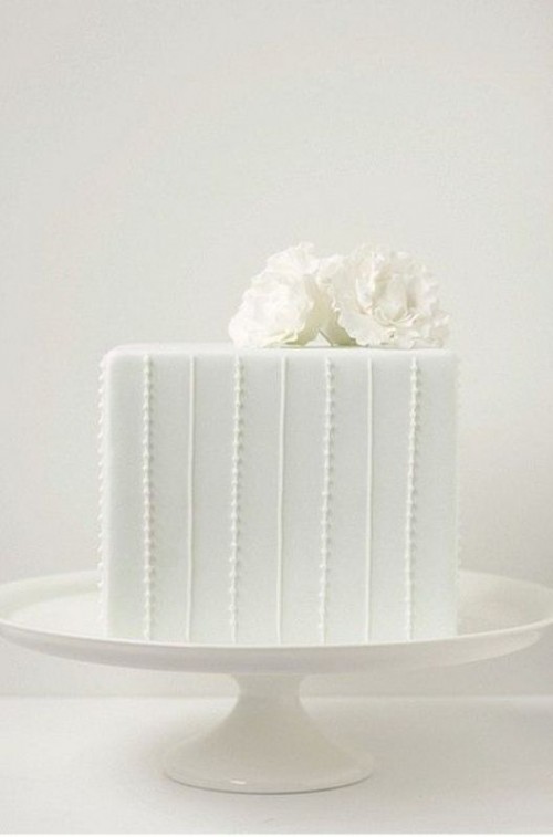 a white square wedding cake with fresh blooms on top is timeless classics for most of modern weddings