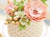 a polka dot one tier wedding cake with sugar blooms and even sugar succulents and berries on top is a playful idea