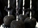black candied apples with sticks and black bows are amazing for a wedding, they can add a bold touch to your dessert table