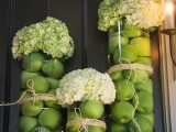 tall glass vases filled with green apples and topped with white hydrangeas is an easy and lovely wedding centerpiece