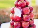 a stack of red apples is a lovely way to display your wedding favors, and it can be an alternative to a wedding cake, a healthy one