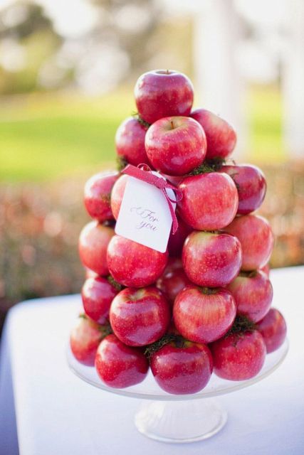a stack of red apples is a lovely way to display your wedding favors, and it can be an alternative to a wedding cake, a healthy one