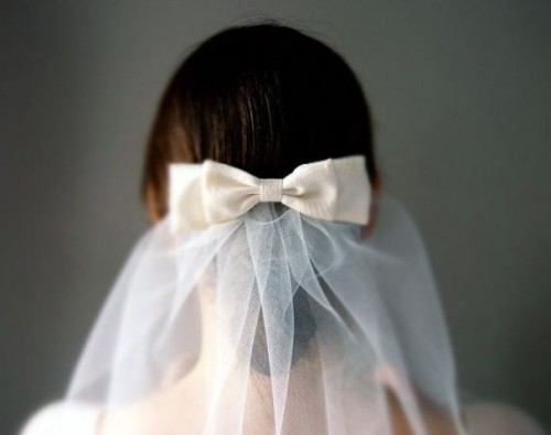 a white silk bow plus a veil are a lovely combo for a chic bridal look, it will give a cute and lovely touch to the look