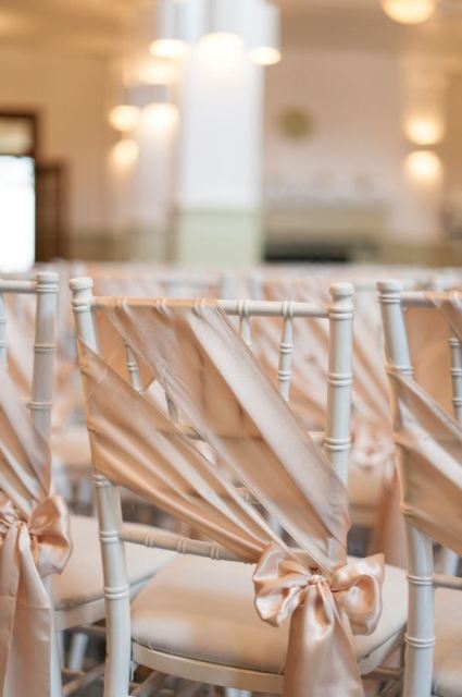delicate blush silk ribbon accenting the wedding chair are a budget-friendly and cool idea for a wedding in pastels or neutrals