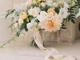 a delicate and subtle wedding bouquet of blush and white blooms and greenery and blush silk ribbons is a beautiful idea for a spring or summer wedding