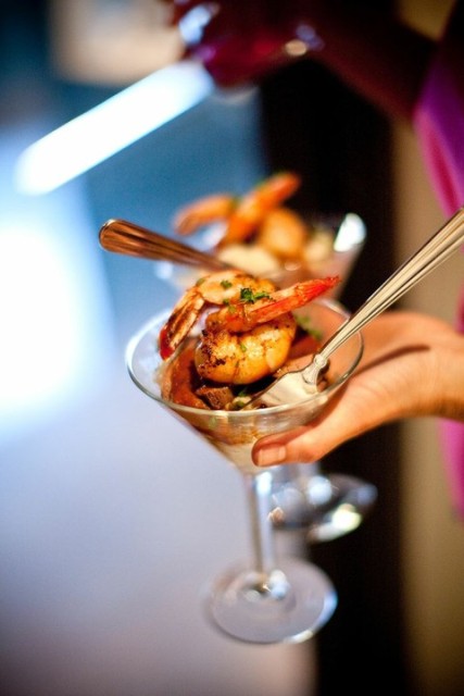 cocktail glasses with grilled shrimps, veggies, greenery and a creamy sauce