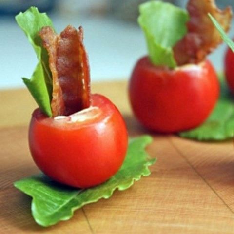 tomatoes on greenery, fried bacon strips, greenery and some sauce inside