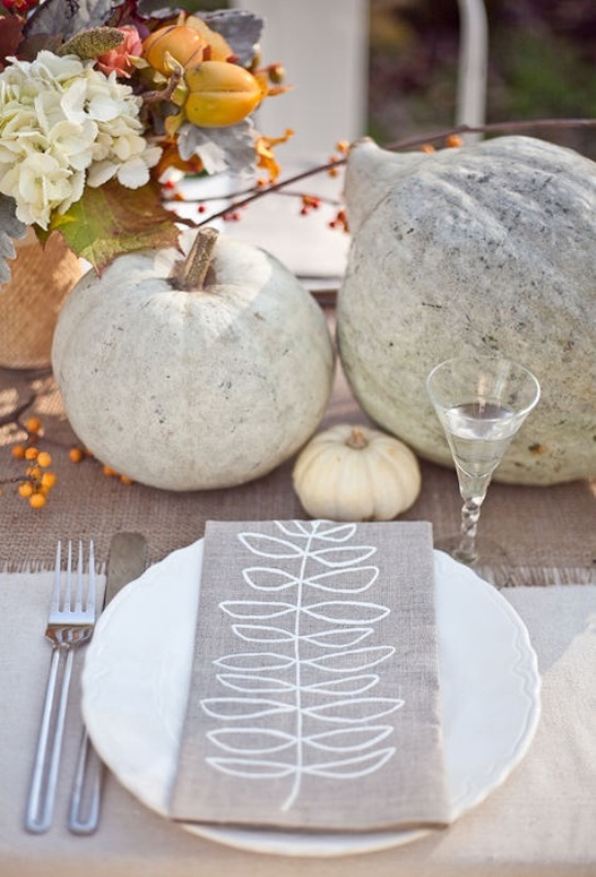 A neutral rustic fall wedding tablescape with a neutral runner, pumpkins, blooms, gourds and other stuff plus a cool printed menu is awesome