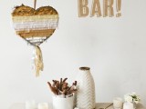 a fun and bold churro bar done with a heart-shaped pinata, blooms and candles
