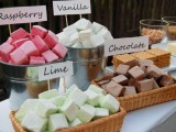 a wedding s’mores bar with various cookies and colorful marshmallows is a cool idea for a camp or rustic wedding