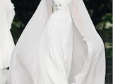 a sheer plain white wedding capelet with a train is a trendy and modern idea for a fall or winter bride