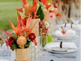 a bright tropical wedding tablescape with bold florals, starfish, tropical leaves and neutral linens and a striped tablecloth