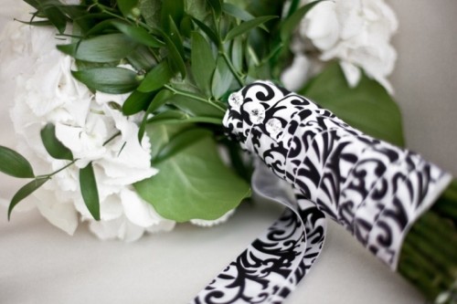 a black and white ribbon wrap with rhinestone pins is a very chic and refined idea