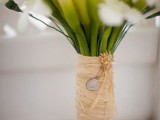 a raffia bouquet wrap with pearls and a mini coin is a cool idea for a rustic wedding bouquet